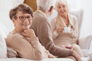 Happy elderly lady enjoying time spent with her family by a cup of tee